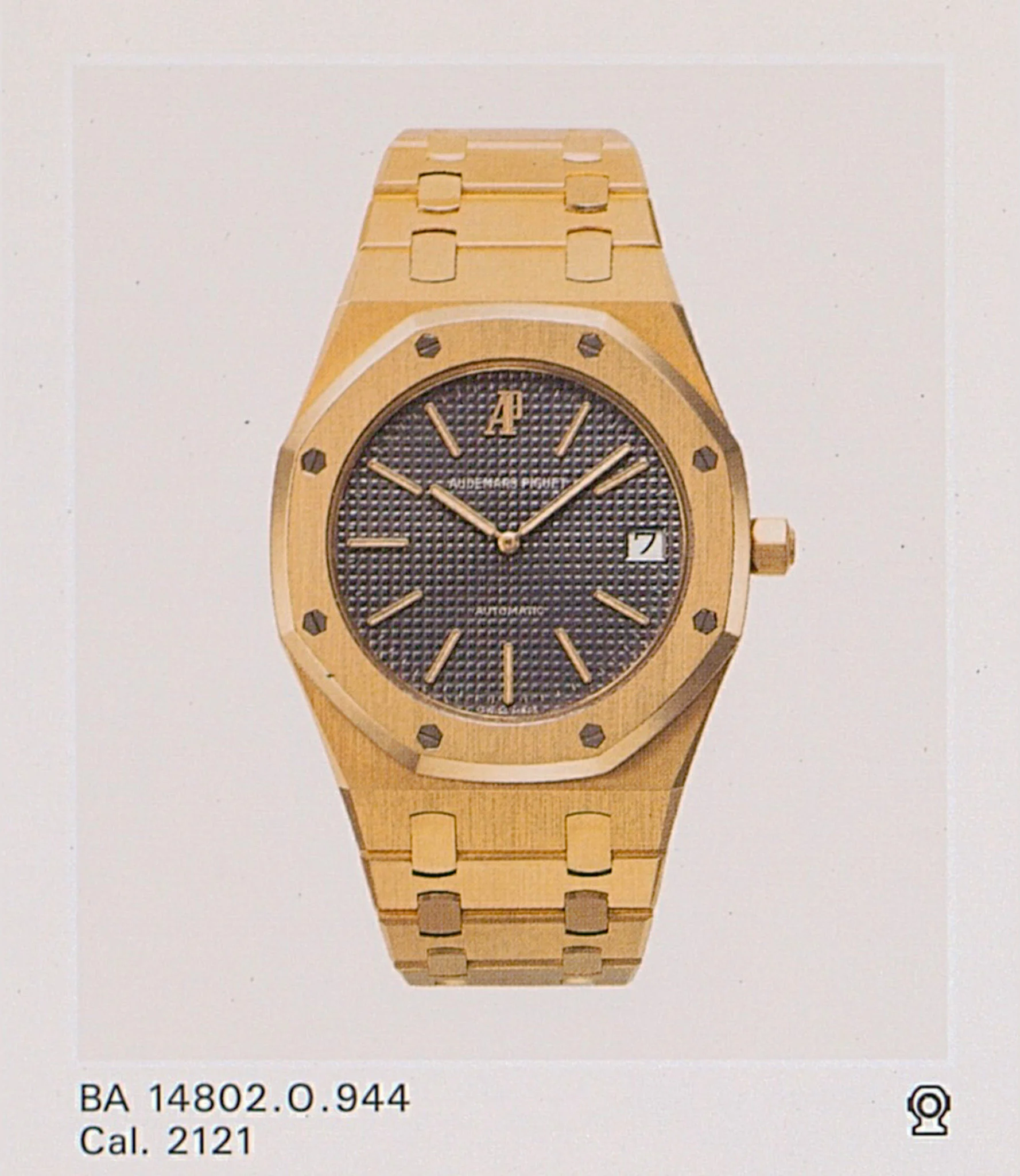 Catalogue photograph captioned “BA 14802.O.944”: yellow-gold case and bracelet 944 with grey Tapisserie dial and AP at 12. · Photo: Audemars Piguet · Licence pending · Source: https://apchronicles.audemarspiguet.com/en/model/14802-royal-oak-jubilee