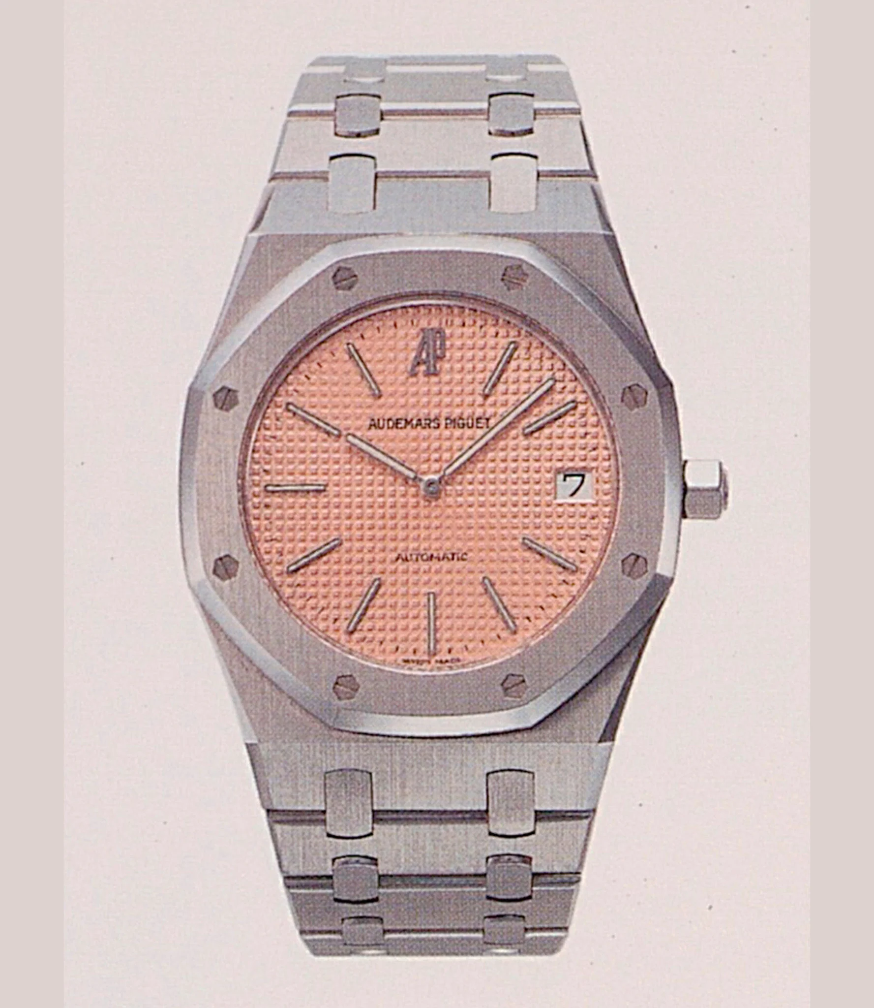 Period AP catalogue photograph of the steel 14802ST with the salmon-pink Tapisserie dial and AP monogram at 12. · Photo: Audemars Piguet · Licence pending · Source: https://apchronicles.audemarspiguet.com/en/model/14802-royal-oak-jubilee